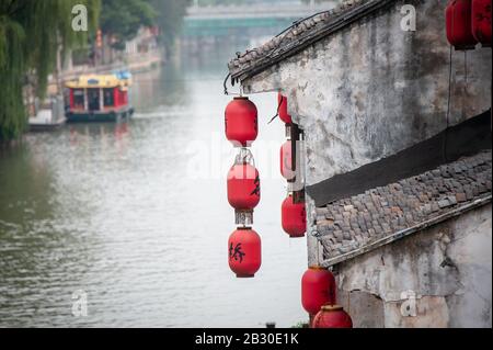 Wuxi, China - October 2019: Ancient town, Wuxi, Jiangsu Province. Chinese lanterns hang from an ancient building along the Grand Canal - China Stock Photo