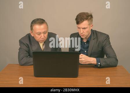 Mature Asian businessman and young Scandinavian businessman together Stock Photo