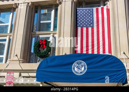 Seal of the US Department Veterans Affairs at the entrance to their office in D.C., the American flag seen hanging above. Stock Photo