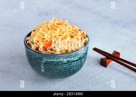 Instant noodles bowl with carrot and scallions, with chopsticks and a place for text Stock Photo