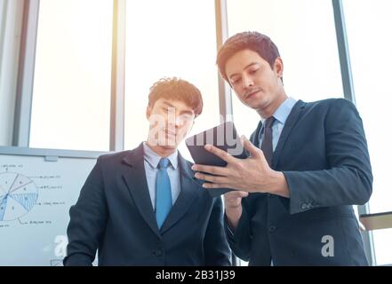 Two young multiracial group businessmen working in modern workplace with technology office.Business and finance concept. Stock Photo