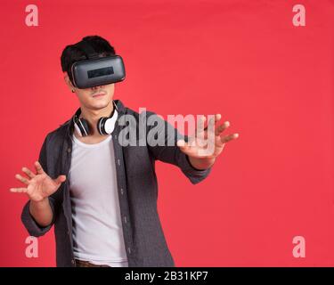 3d technology, virtual reality, entertainment, cyberspace and people concept - happy young caucasian handsome man with virtual reality headset or 3d Stock Photo