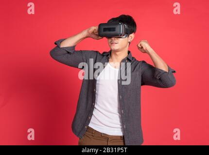 3d technology, virtual reality, entertainment, cyberspace and people concept - happy young caucasian handsome man with virtual reality headset or 3d g Stock Photo