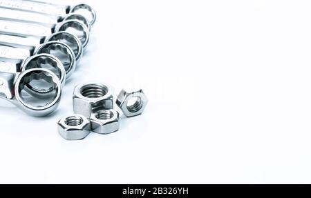 Metal hexagon nuts and chrome wrenches isolated on white background. Mechanic tools for maintenance. Hardware tool. Fastener with a threaded hole. Set Stock Photo
