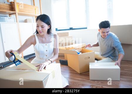 startup small business owner at workplace. freelance asian man and asian woman seller check product order, packing goods for delivery to customer. Onl