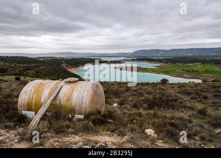 Fiberglass water tank and reservoir with turquoise waters in spring on background. Drought and climate change concept. Buendia reservoir, La Alcarria Stock Photo