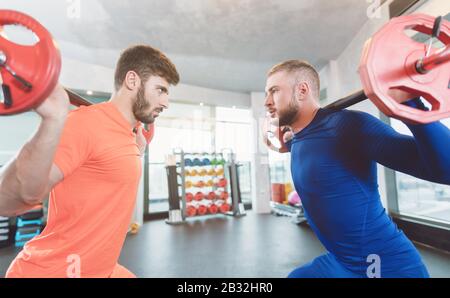 Two competitive young man lifting weights in the gym Stock Photo