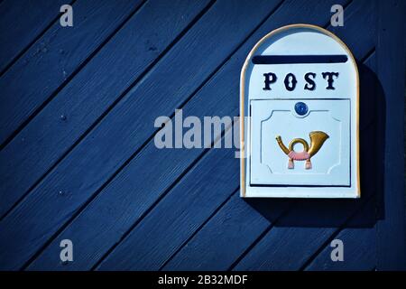 Old postbox on blue wooden door. Background. Texture Stock Photo