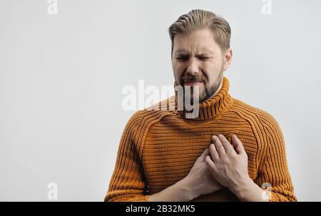 Grimacing man suffering from heartache Stock Photo