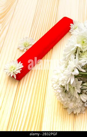Romantic gift concept. Valentines day or 8th march or love holiday. Present case and flowers. Table setting on wooden background. Stock Photo