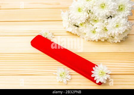 Romantic gift concept. Valentines day or 8th march or love holiday. Present case and flowers. Table setting on wooden background. Stock Photo