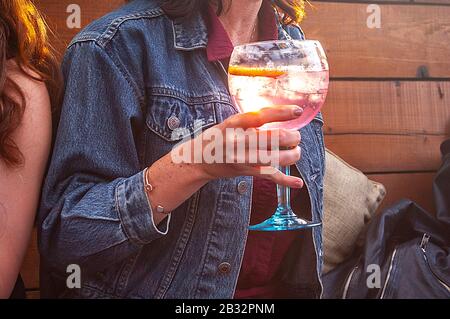 KENSINGTON, LONDON/ENGLAND – JULY 18 2019: Woman drinking pink gin in summertime Stock Photo