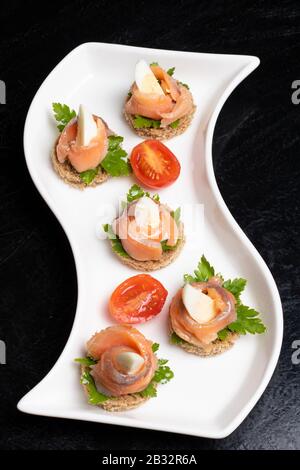 Sandwiches with salmon, cured bresaola, crayfish, tomatoes, quail eggs and sour cream. Japanese meal Stock Photo
