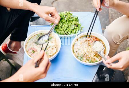 Close up of couple tasting oriental Vietnamese food Stock Photo