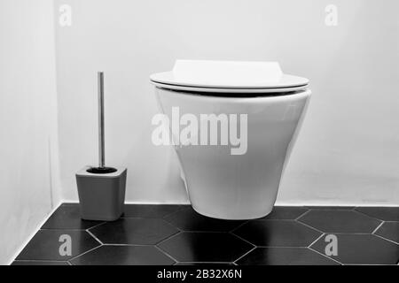 Suspended toilet in wc with black tiles on the floor Stock Photo