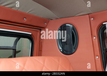 An audio speaker mounted on a wall at the rear of the car for a multimedia system. Auto service industry. Stock Photo
