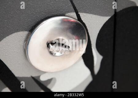 Chromed metal gas tank filler cap with inscription fuel. The rise in oil and fuel prices in the world market. Saving on diesel using electric vehicles Stock Photo