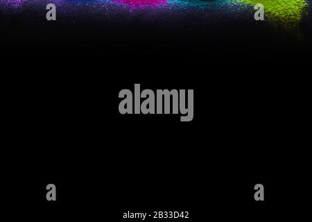 Multi-colors powder sprayed on black background. Holi celebration Stock Photo