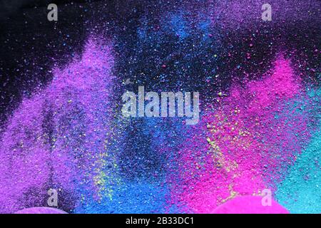 Multi-colored powder sprayed on black background. Holi celebration Stock Photo
