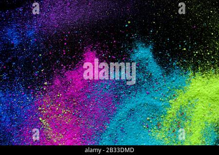 Multi-colored powder sprayed on black background. Holi celebration Stock Photo