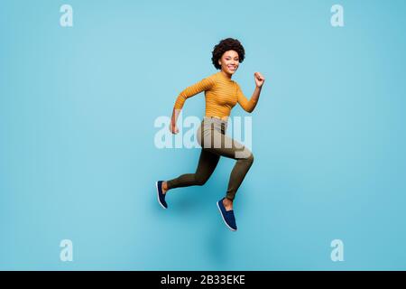 Full length body size view of nice lovely healthy cheerful active confident strong wavy-haired girl running having fun isolated on bright vivid shine Stock Photo