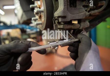 Stuttgart, Germany. 03rd Mar, 2020. A car mechanic is measuring the brake disc of a Range Rover Evoque in a garage. Credit: Marijan Murat/dpa/Alamy Live News Stock Photo