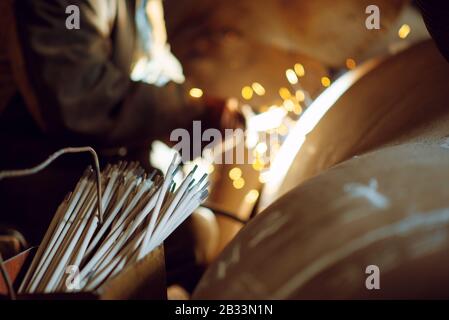 Welder in mask works with metal construction Stock Photo