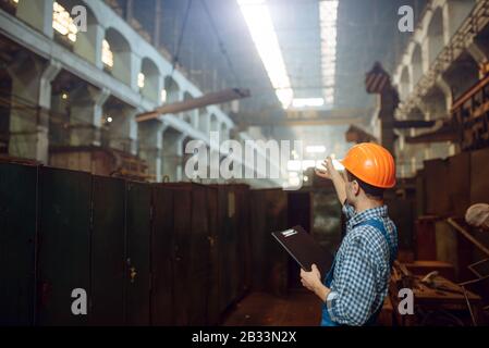 Master shows thumbs up to crane operator, factory Stock Photo