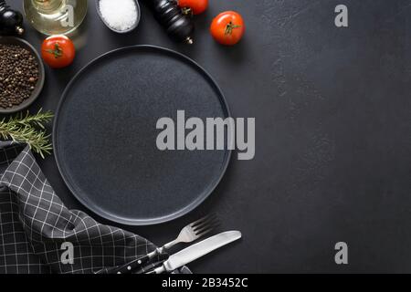 Backdrop with gray platter, spices and ingredients for cooking marinade tasty dishes on black. Space for text. View from above. Stock Photo
