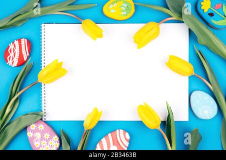 Isolated text space surrounded by yellow tulips and Easter eggs. Stock Photo