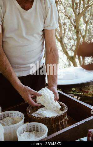 Details of man making cottage cheese outdoors in a traditional way. Traditional ricotta production in Sicily on the Madonie. Stock Photo