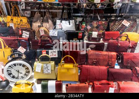 Discounted bags for sale in a shop window, Venice, Italy Stock Photo