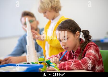Girl looking at buildable bird, boy building a tower Stock Photo