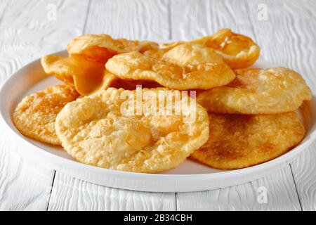 close-up of Bhatura, indian deep fried leavened bread on a white platter on a wooden table, horizontal view from above Stock Photo