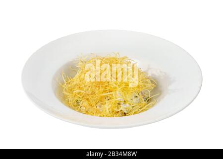 Salad with fried potatoes, a bunch of eggs, pickled cucumbers, mushrooms, mayonnaise, meat, beef, pork, onions on plate, white isolated background Sid Stock Photo