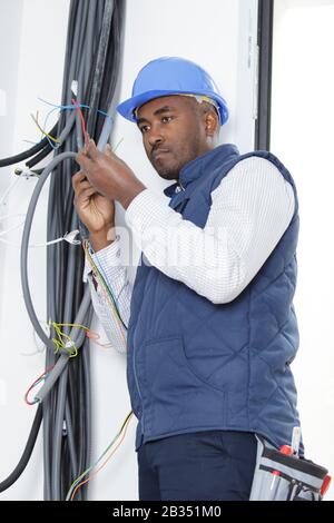 man in hardhat dealing with cables Stock Photo