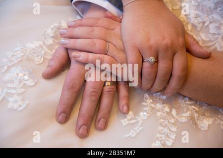 bride and grooms hands in close up showing their wedding rings on their wedding day, no identifiable people Stock Photo