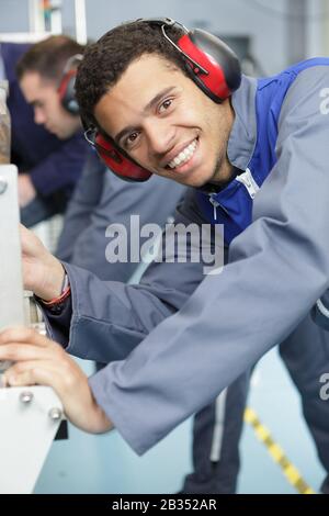 portrait of happy young worker in factory Stock Photo