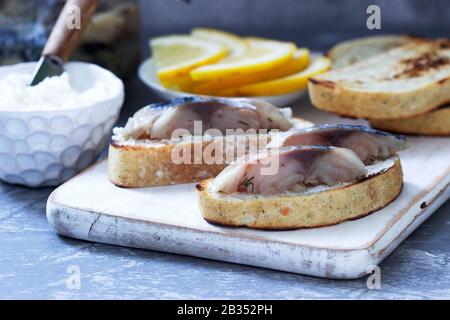 Sandwiches with cottage cheese and gravlax from mackerel, served with lemon. Stock Photo