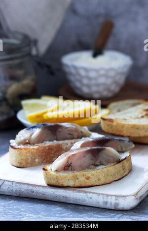 Sandwiches with cottage cheese and gravlax from mackerel, served with lemon. Stock Photo