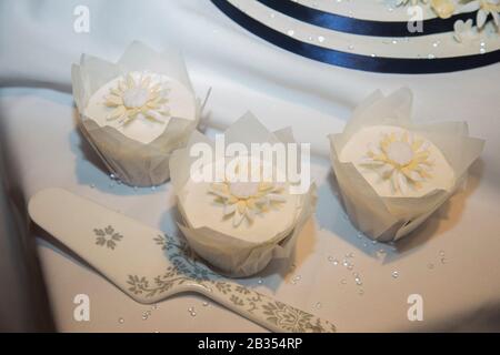 Wedding Day cup cakes with white icing and white iced flower decorations on top Stock Photo