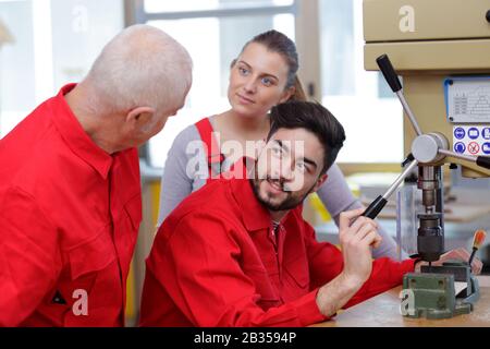 student and teacher in carpentry class using circular saw Stock Photo