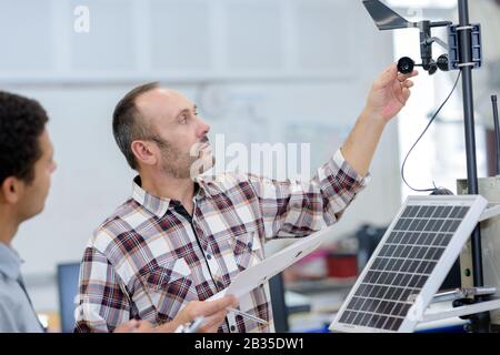 two engineer or installer inspecting solar energy panels Stock Photo