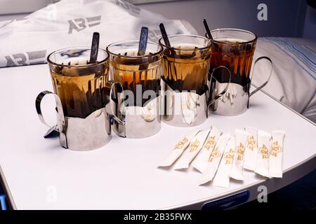 Four glasses with tea in metal holders on table at the train. Stock Photo