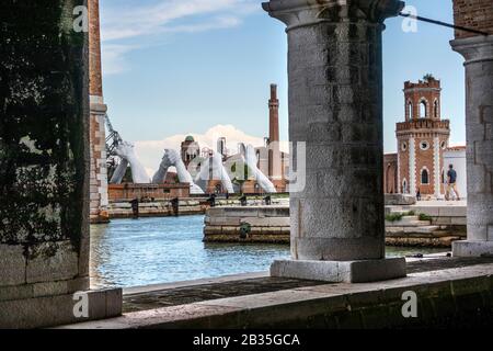 Italian artist Lorenzo Quinn builds bridges over Venice Arsenale, Italy. Six pairs of arching hands creating a bridge over a Venetian waterway, symbolic of the need to build bridges and overcome divisions. Stock Photo