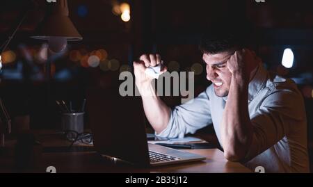 Aggressive Office Manager Crumpling Paper Sitting Overnight In Office Stock Photo