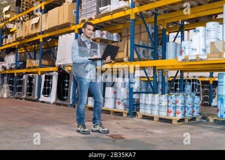 worker checking goods on belt in distribution warehouse Stock Photo