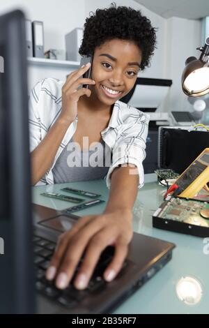 happy female technician using multimeter Stock Photo