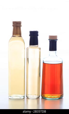 Vinegar bottles isolated. Transparent glass bottles with vinegars variety isolated against white background, vertical Stock Photo