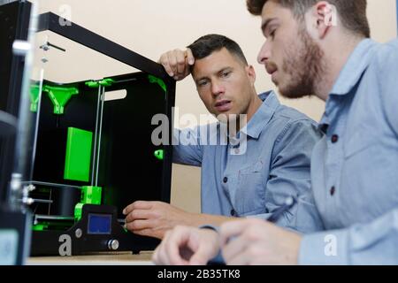 two male technicians using 3d printer Stock Photo